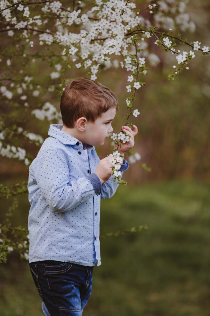 chlapec při jarním focení s bílými květy