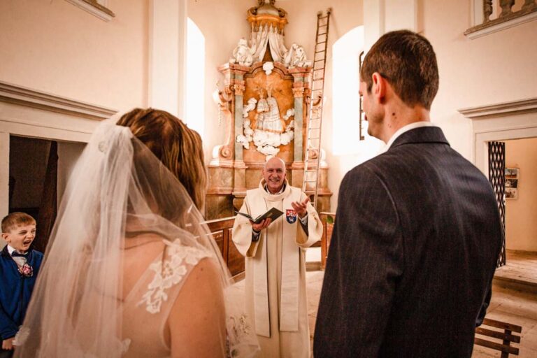 nevěsta a ženich při obřadu s knězem