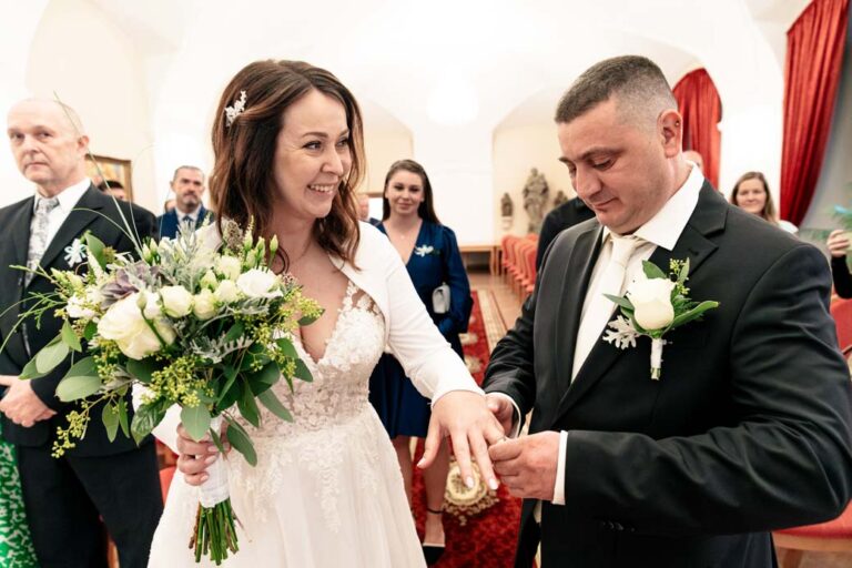 ženich a nevěsta si nasazují prsteny při svatebním obřadu